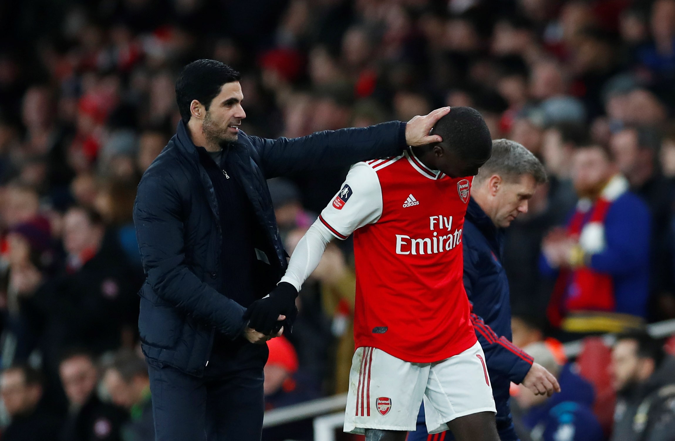 nicolas pepe being patted on the head by mikel arteta